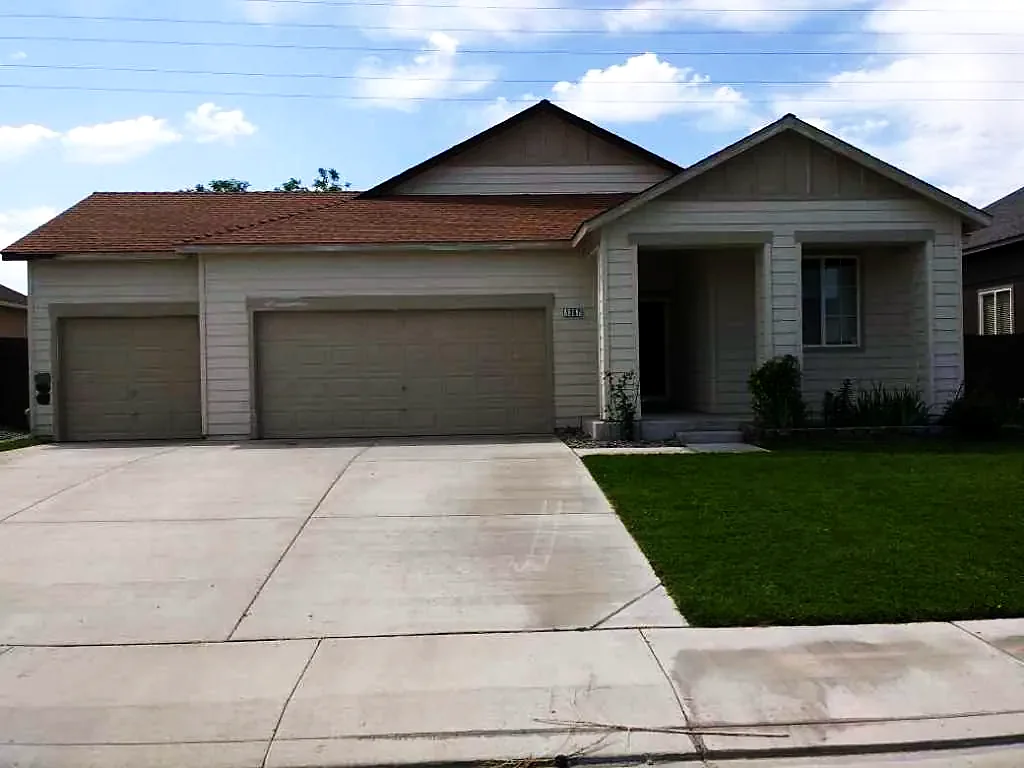 Grey stucco home with three‑car garage