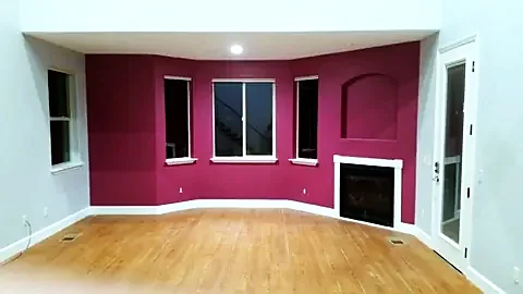 Living room painted deep plum with white trim